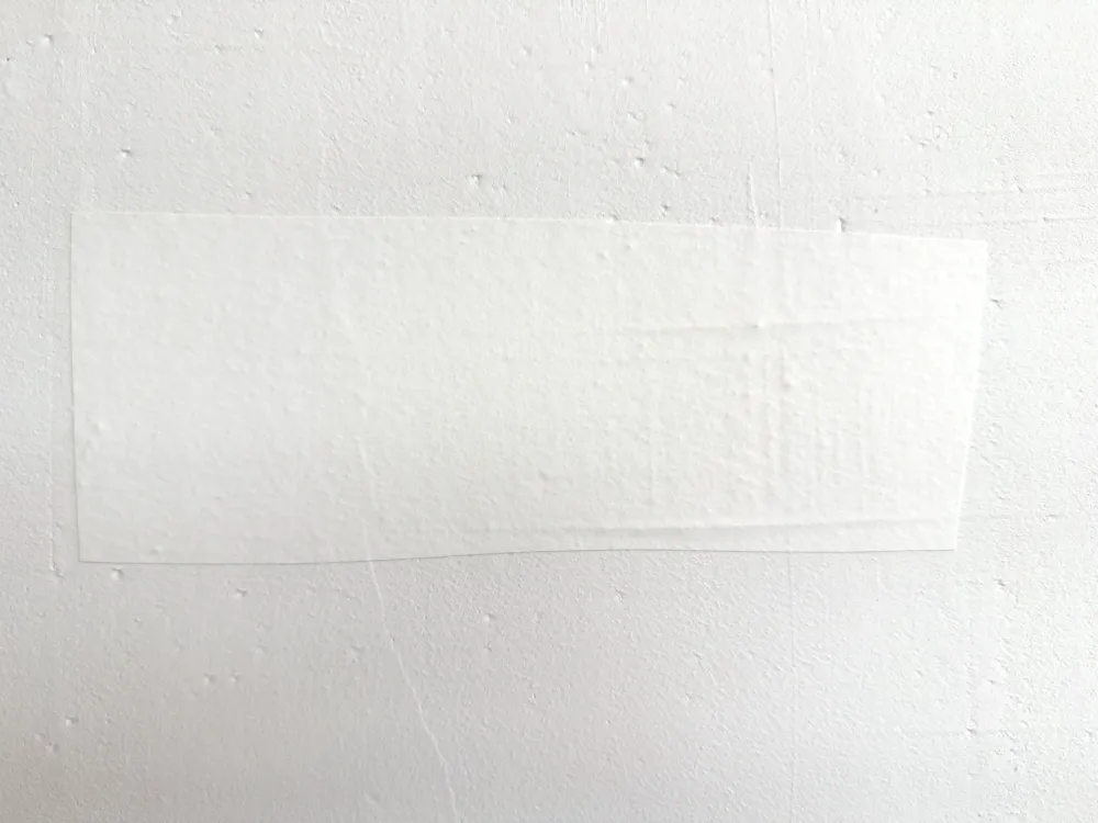 Baan renovlies op een onvoorbewerkte muur, waar de oneffenheden doorheen tekenen