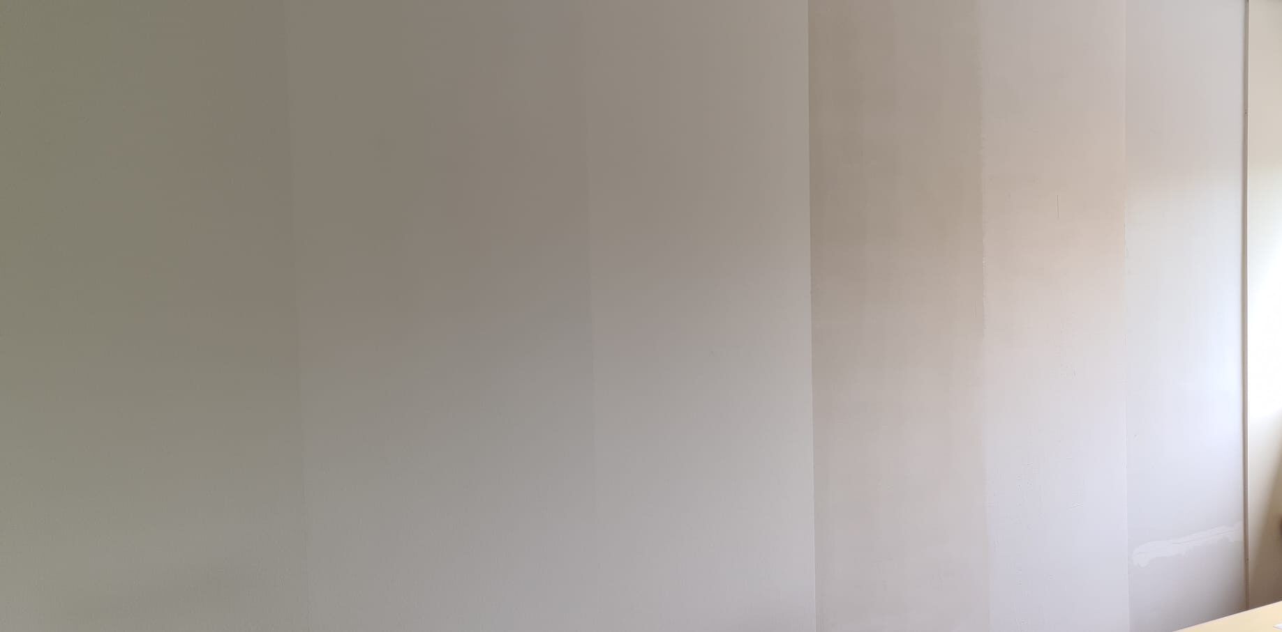 Muur met verschillende lagen van renovlies behang in het opbouwproces.