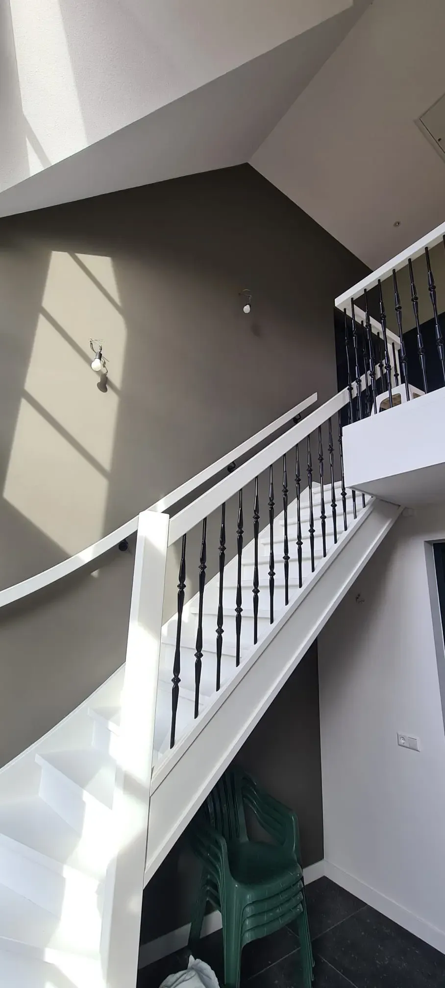 Witte renovlies trap en taupe latex gekleurde muur in een hal, met een gladde afwerking.