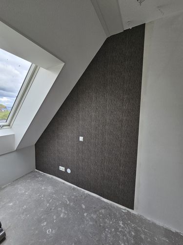 Structuurbehang op een schuine zolderwand: precisiewerk tot in de nok
